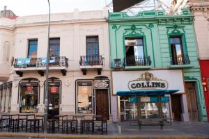 a building with tables and chairs on a city street at Real Ros Hostel in Rosario