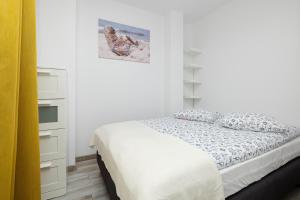 a white bedroom with a bed and white shelves at SŁONECZNE TARASY in Pustkowo