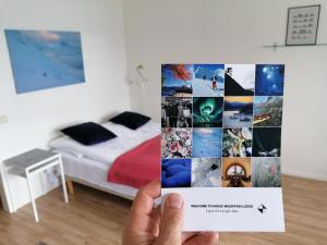 a person holding up a collage of photos in a bedroom at Magic Mountain Lodge - Lyngen in Lyngseidet