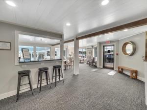 a living room with bar stools and a dining room at 201 Pointes North Inn in Charlevoix
