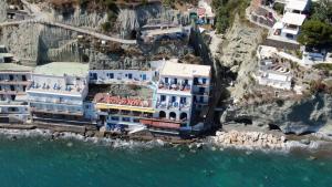 a large building on the side of a cliff next to the water at Hotel Angelino in Ischia