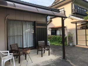 a patio with two chairs and a table and chairs at Youyousanso Apartment in Mie in Tsu