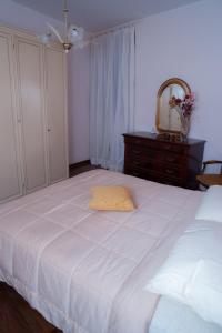Civitella dʼAglianoにあるCasa Floraのベッドルーム1室(鏡付き白いベッド1台、ドレッサー付)