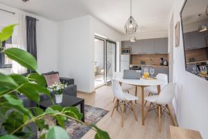 cocina y sala de estar con mesa y sillas en Apartments Maella, en Zadar