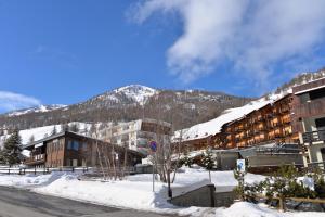 a building in the snow with a mountain in the background at House La Motta by Holiday World in Borgata Sestriere