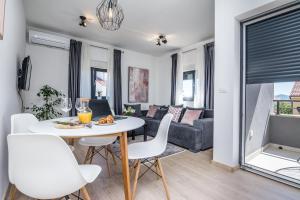 salon ze stołem, krzesłami i kanapą w obiekcie Apartments Maella w mieście Zadar
