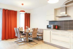 a kitchen and dining room with a table and chairs at Sunny Apartment in Prague