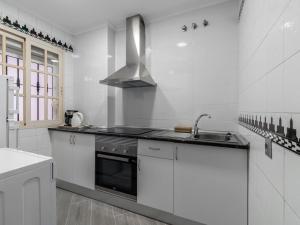 a white kitchen with a sink and a stove at Apartment Pueblo Quinta-3 by Interhome in Benalmádena