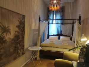 a bedroom with a canopy bed with a chandelier at Boutique Hostel LEKKERURLAUB in Berlin