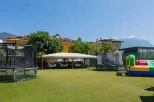 a park with a playground and a white canopy at Hotel Campagnola in Riva del Garda +44 photos