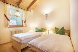 two twin beds in a room with a window at Chalet Crepes De Sela in Canazei