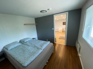 1 dormitorio con 1 cama y puerta que da a un pasillo en Sukkertoppen Apartment, en Ålesund