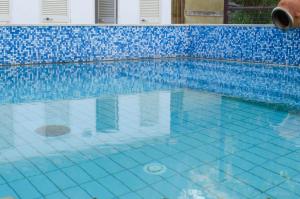 a large swimming pool with blue tiles on it at Hotel Angelino in Ischia
