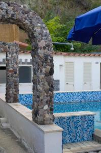 a stone archway next to a swimming pool at Hotel Angelino in Ischia