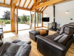 uma sala de estar com mobiliário de couro e uma lareira em Fron Goch Farm em Abergele