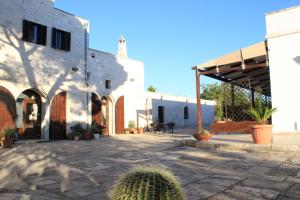 een binnenplaats van een gebouw met cactussen ervoor bij Masseria Valente in Ostuni