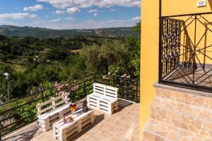 two white benches sitting on a balcony with a view at Affittacamere Al Corso in San Martino dʼAgri