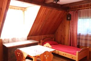 a bedroom with a bed and a table and a window at Pan Tadeusz in Nowy Targ