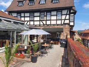 シュリッツにあるHotel & Café Schachtenburgのテーブルと椅子、傘が備わる建物