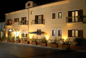 un gran edificio blanco con una sombrilla delante en Hotel Paradiso Delle Madonie en Castelbuono