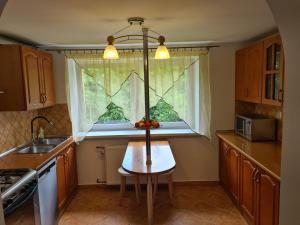 a kitchen with a table in front of a window at Apartament pod wieżą Sky Walk in Świeradów-Zdrój