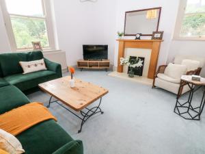 uma sala de estar com um sofá verde e uma mesa em Eastview em Matlock