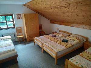 a bedroom with two beds and a wooden ceiling at Na Hrázi in Český Krumlov