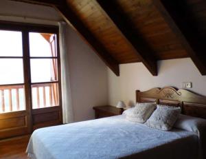 a bedroom with a large bed and a large window at Casa Planominguero in Taull
