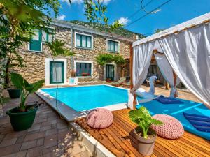 a swimming pool with a deck and a house at Holiday Home Villa Anđelika by Interhome in Drivenik