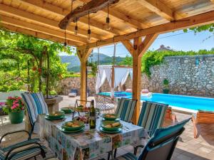 a patio with a table and chairs and a pool at Holiday Home Villa Anđelika by Interhome in Drivenik
