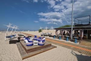 a beach with blue and white chairs and a building at Second Floor Apartament in Liepāja