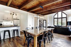 uma cozinha e sala de jantar com mesa e cadeiras em Chalets Alpins 44 Chemin des Skieurs em Stoneham