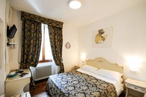 1 dormitorio con cama, escritorio y ventana en Hotel Terzo Crotto, en Cernobbio