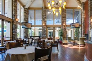 a dining room with tables and chairs and windows at Pala Mesa Resort in Fallbrook