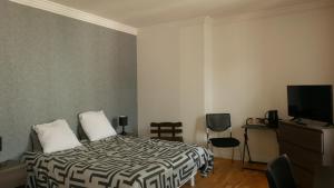ein Hotelzimmer mit einem Bett und einem TV in der Unterkunft La Boule d'Or in Bourganeuf
