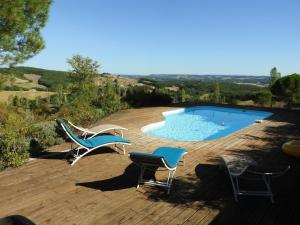 a patio with two chairs and a swimming pool at LA DAME FINES in Puybegon