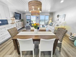 a kitchen and living room with a table and chairs at Endless Waves -208 ES Condo in Santa Rosa Beach