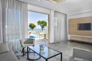 a living room with a tv and a glass table at Pernera Beach Hotel in Protaras