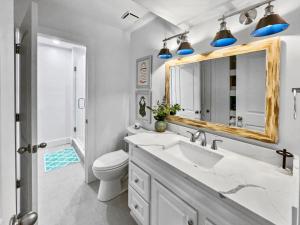a bathroom with a sink and a toilet and a mirror at Endless Waves -208 ES Condo in Santa Rosa Beach