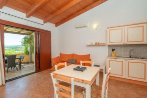 uma cozinha e uma sala de jantar com uma mesa e um sofá em Villa Circe em Santa Teresa Gallura