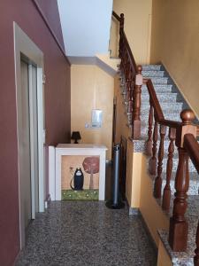 einen Flur mit Treppe mit einem Bild einer Katze in der Unterkunft Pension KM66 in Palas de Rei
