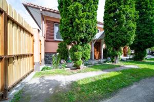a house with trees in front of a yard at Be my apartman in Odorheiu Secuiesc