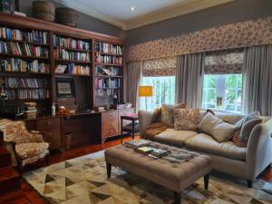 a living room with a couch and book shelves at The Great Gatsby Houghton in Johannesburg