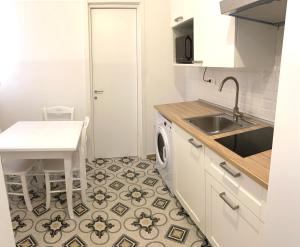 uma cozinha com um lavatório e uma máquina de lavar roupa em Domina Living Apartments - Presepe em Bisceglie