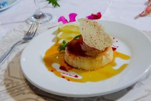 a white plate with a piece of food on a table at Dunia Hôtel Ouagadougou Loumbila in Loumbila