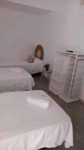 een hotelkamer met 2 bedden en een tafel bij El Pez Naranja in Zahara de los Atunes