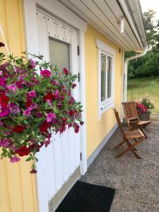 un porche con una cesta de flores al lado de una casa en Villa Syren, en Söderköping