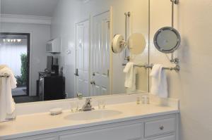 un bagno con un lavandino e un grande specchio di 657 Cottages at Silverado residence a Napa Altre 4 foto