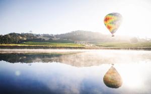 einem Heißluftballon, der über einen Wasserkörper fliegt in der Unterkunft 683 Cottages at Silverado residence in Napa