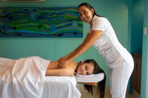 a woman helping a woman on a bed at Alma del Pacifico Hotel & Spa in Esterillos Este